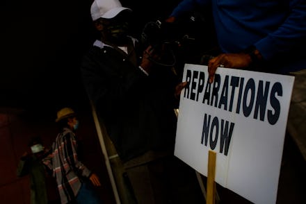 TULSA, OK - NOVEMBER 18: Vernon AME Church pastor Robert Turner holds a reparations now sign after l...
