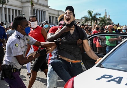 TOPSHOT - A man is arrested during a demonstration against the government of Cuban President Miguel ...