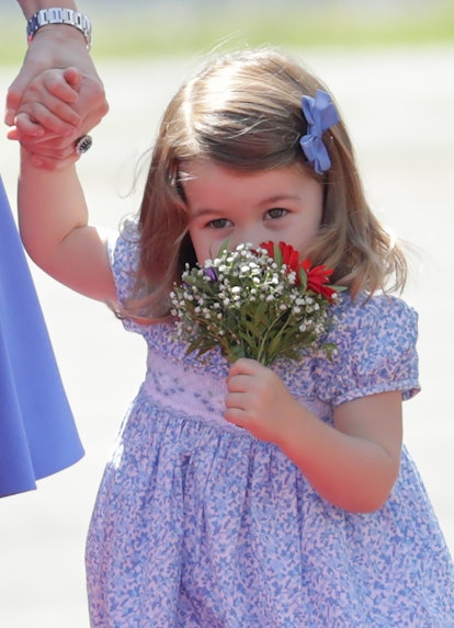 Princess Charlotte sniffs a bouquet of flowers.
