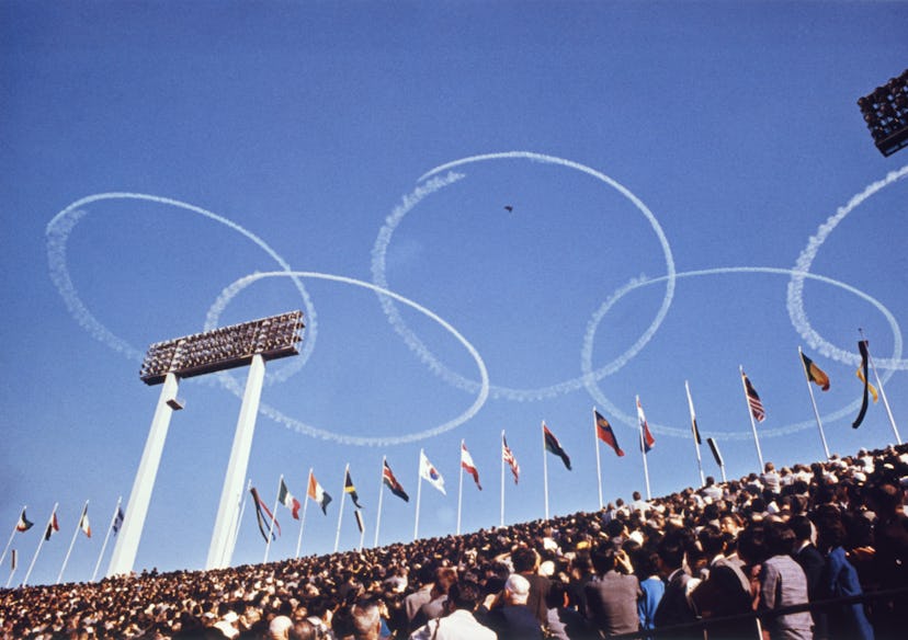 Sky writers trace the Olympic symbols, interlocking rings, in the air above the National stadium on ...