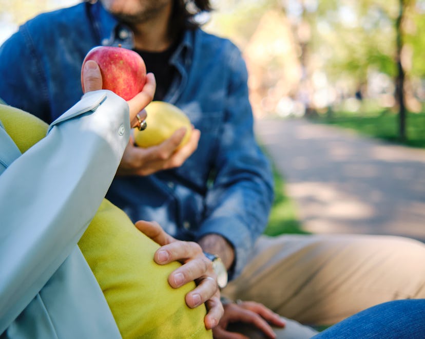 pregnant woman and her husband sitting on a bench