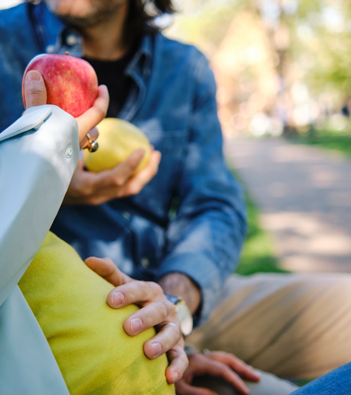 pregnant woman and her husband sitting on a bench