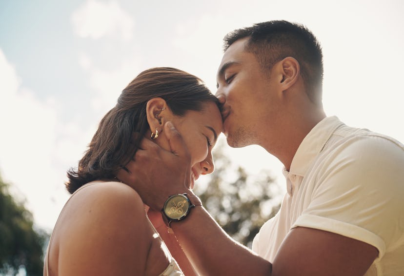 A boyfriend kissing his girlfriend on the forehead