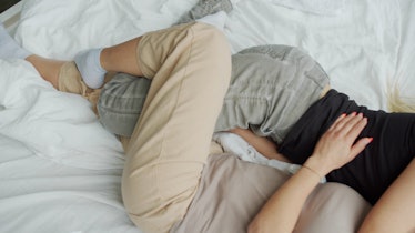 two people laying in bed with their legs intertwined