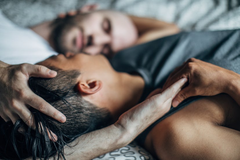 Homosexual men couple lying in bed together