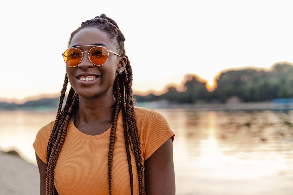 Jovem afro-americana está ao ar livre, ela está sorrindo