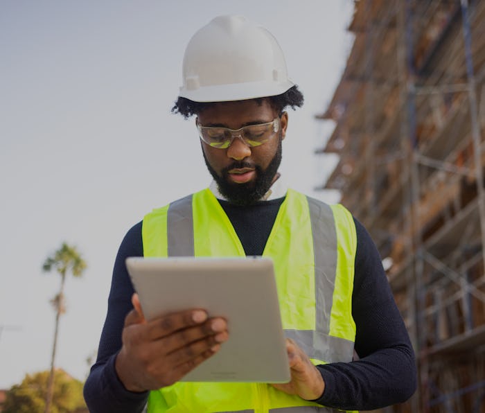 A young black man is a project manager at a residential construction site.