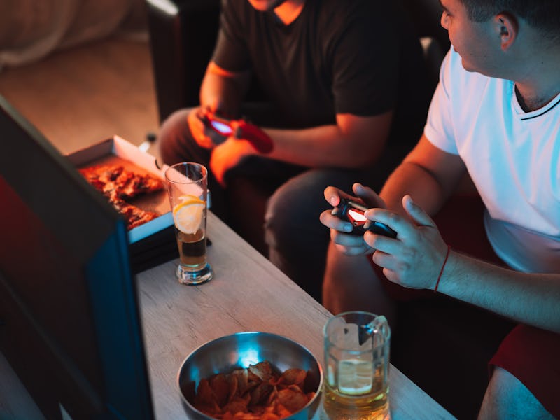 Guys playing video games holding joysticks.