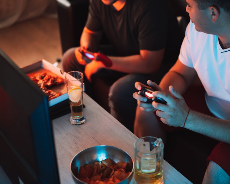 Guys playing video games holding joysticks.