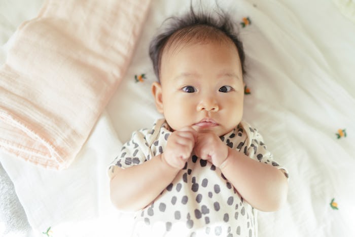 baby girl lying on blanket looking at camera