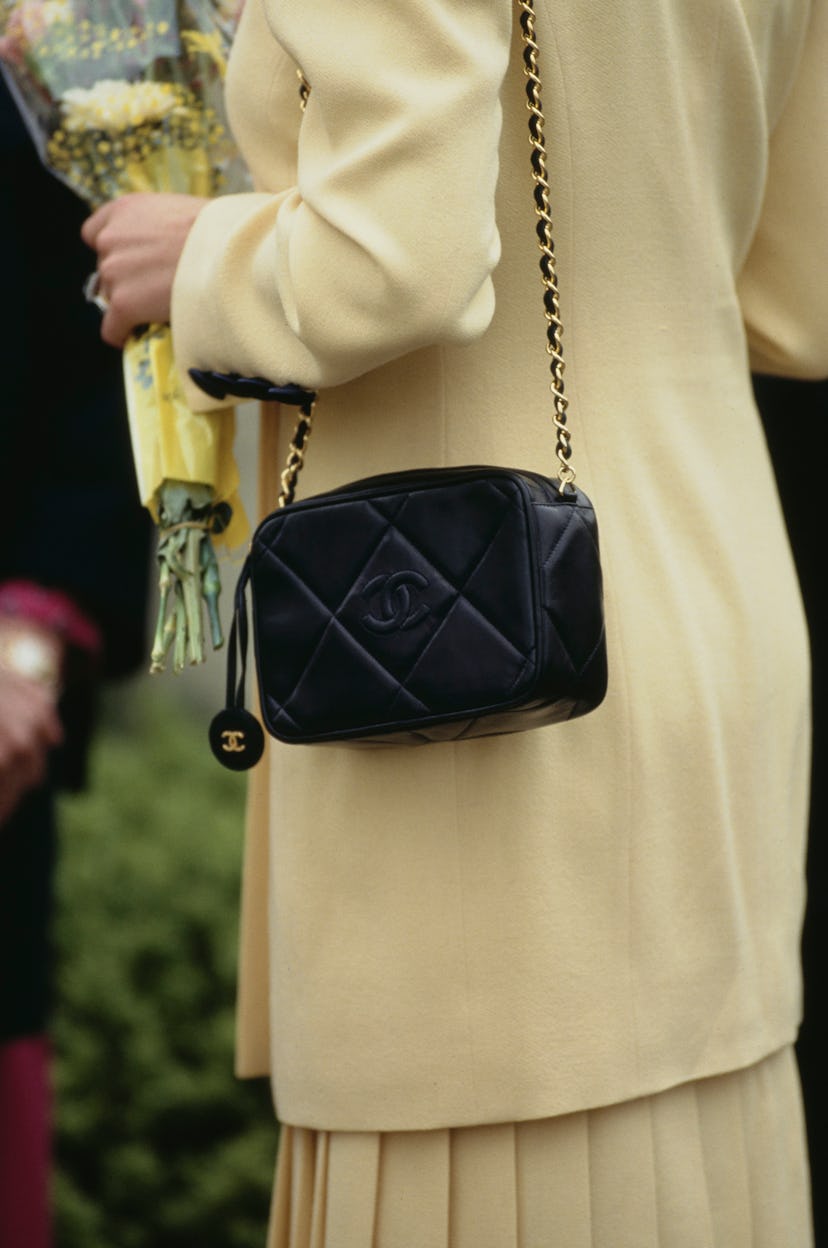 Diana, Princess of Wales wearing a yellow skirt suit and a Chanel quilted bag