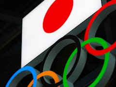 TOKYO, JAPAN - 2021/03/15: Japanese flag with Olympic Rings above the entrance to the  Japan Olympic...