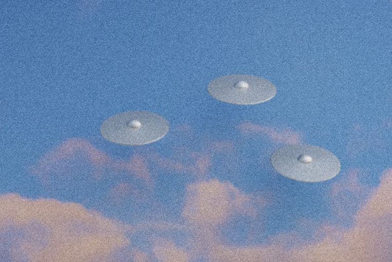 Three flying saucers in blue sky with clouds. Bad quality grainy photo of UFOs. Circular alien flyin...
