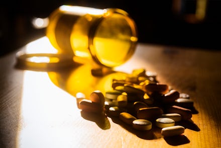 Prescription pills spilled out onto a night stand.
