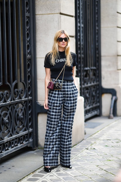 Camille Charriere wears a black ribbed with white Chanel rhinestones logo crop-top from Chanel, blac...