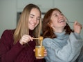 2 friends smiling and tasting their honey jelly recipe from TikTok.