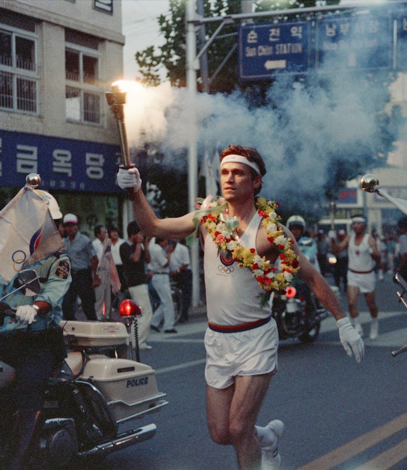 Lawrence Mac Donald holds the olympic flame in the streets of Seoul on August 30, 1988. (Photo by - ...