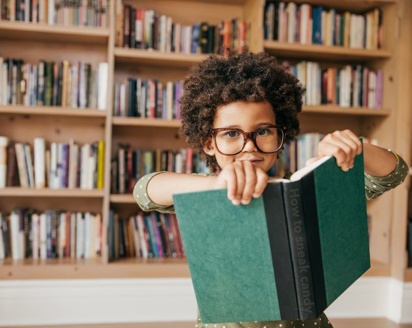 little boy wearing glasses and holding a book in an article round up of back-to-school poems