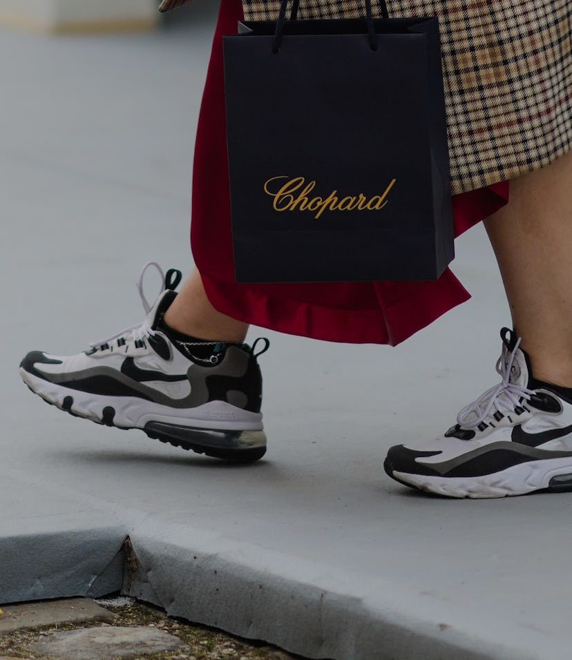 PARIS, FRANCE - JULY 05: A guest wears a beige with black and red checkered long oversized coat, a b...
