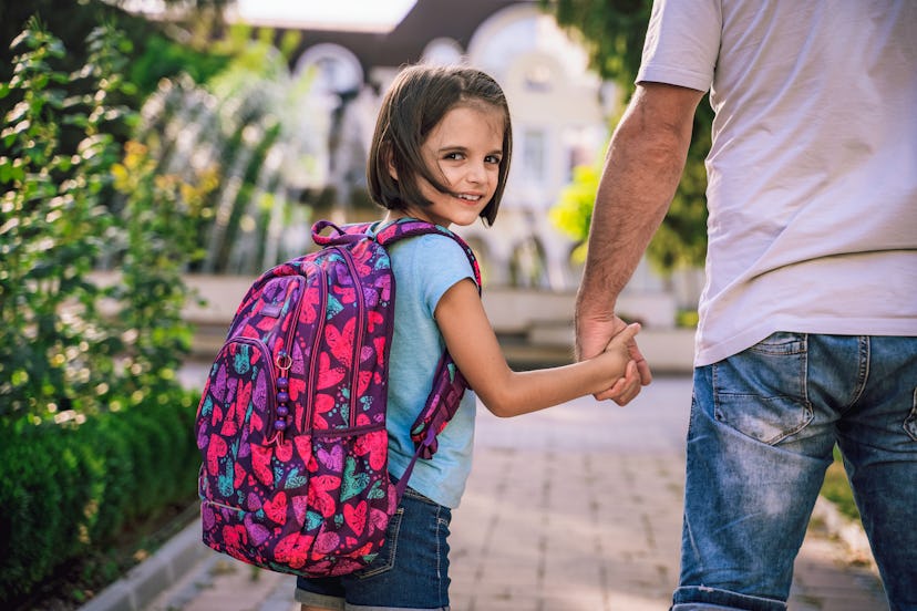 little girl wearing a backpack on first day of school
