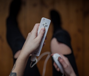 Gothenburg, Sweden - January 17, 2015: A shot from above of a young woman's hands holding Wii remote...