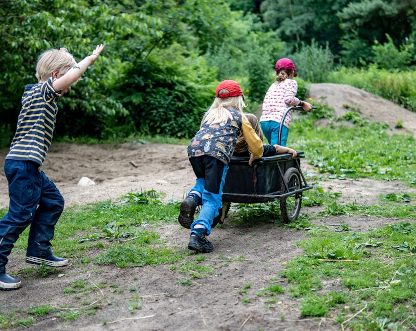Children from the Wühlmäuse daycare center play with a trailer in the forest