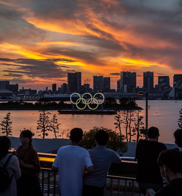 TOKYO, JAPAN - JULY 21: People gather to look at Olympic rings at sunset on July 21, 2021 in Tokyo, ...