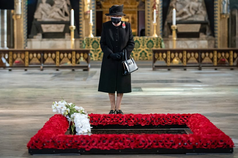 Queen Elizabeth II inspects a bouquet of flowers placed on her behalf at the grave of the Unknown Wa...