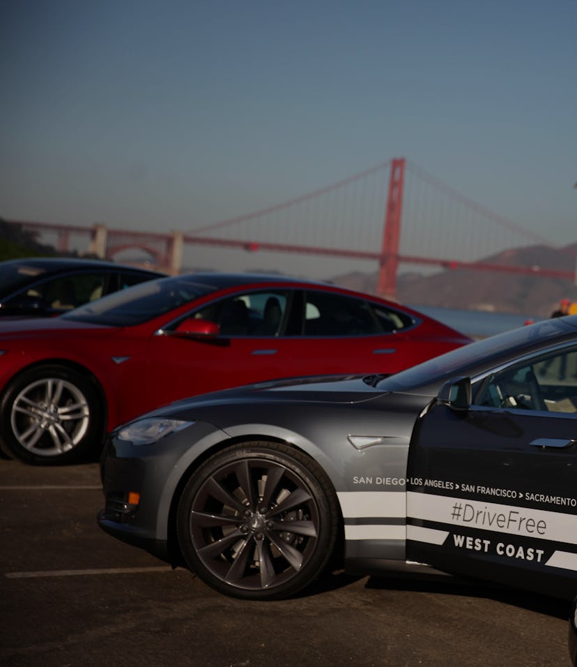 Daniel Myggen, Tesla sales operations, gets out of a Tesla Model S after parking it during a stop in...