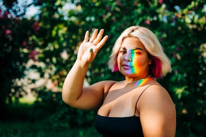 Young woman with a rainbow refraction on her face, waiting to hear her August 2, 2021 weekly horosco...