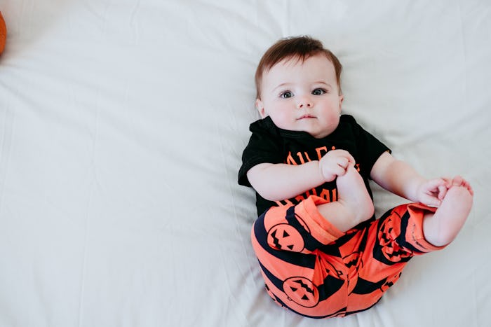 baby wearing halloween jack o' lantern pants