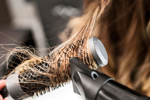 Young woman at a hair salon with hairdresser, hair drying