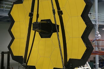 GREENBELT, MD - NOVEMBER 02: A technician stands next to the James Webb Space Telescope during asse...