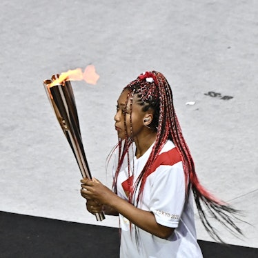 Japan's tennis player Naomi Osaka carries the Olympic torch in the Olympic Stadium during the openin...