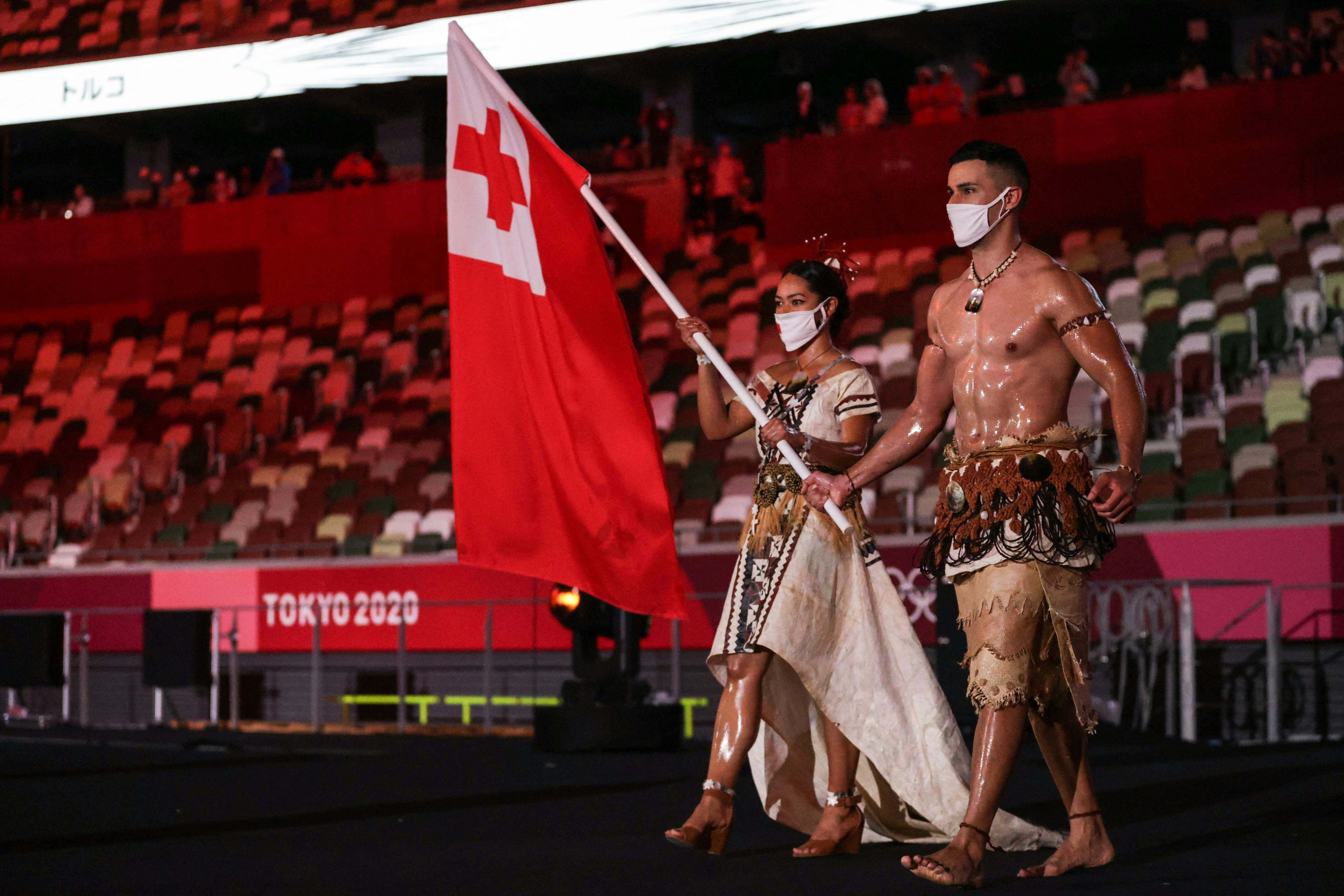 TOPSHOT - Tonga's flag bearers Malia Paseka (L) and Pita Taufatofua lead the delegation during the T...
