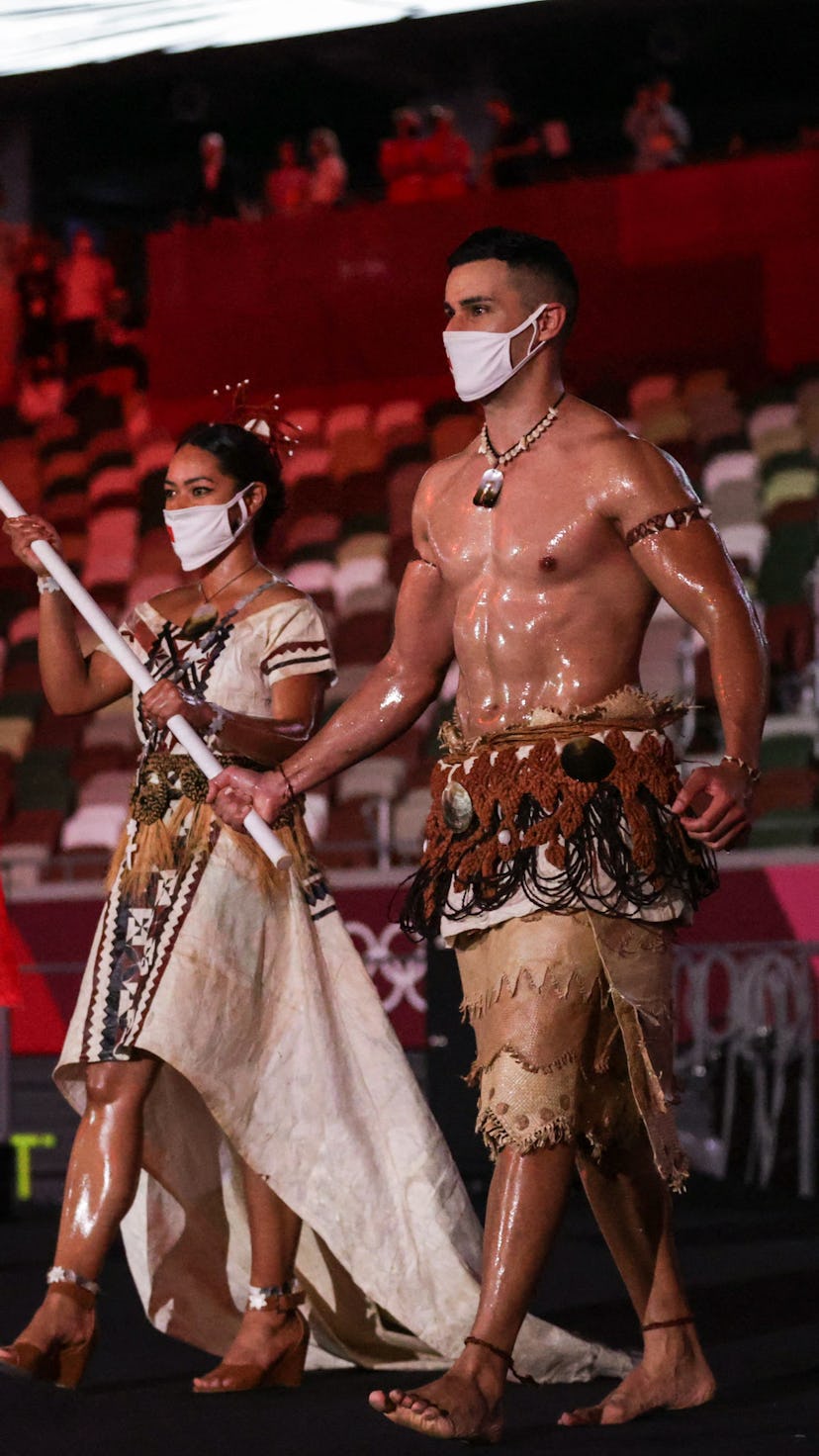 TOPSHOT - Tonga's flag bearers Malia Paseka (L) and Pita Taufatofua lead the delegation during the T...