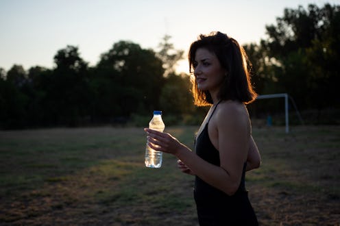 Beautiful sportswoman having water after outdoor workout