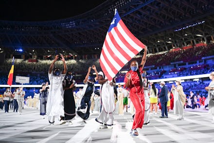 TOKYO, JAPAN - JULY 23: Flag bearers Ebony Morrison and Joseph Fahnbulleh of Team Liberia walk their...