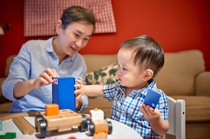 mom and toddler playing with a toy train