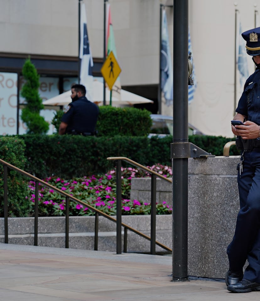 NEW YORK, NEW YORK - AUGUST 01:  An NYPD officer wearing a protective mask looks at his phone at Roc...