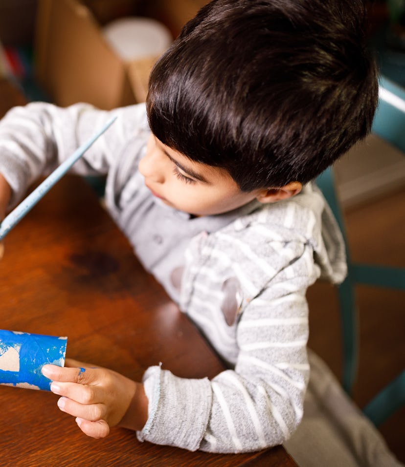 Boy making arts and crafts with paper towel roll