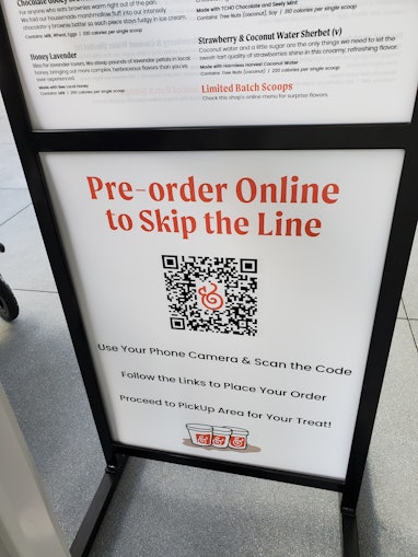 Close-up of a QR coded "Pre-order Online to Skip the Line" and menu sign outside a Salt and Straw ic...