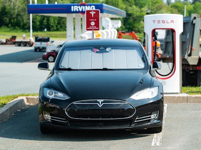 Enfield, Canada - June 7, 2021 - A Tesla Model S sedan at a Supercharger charging terminal at a gas ...