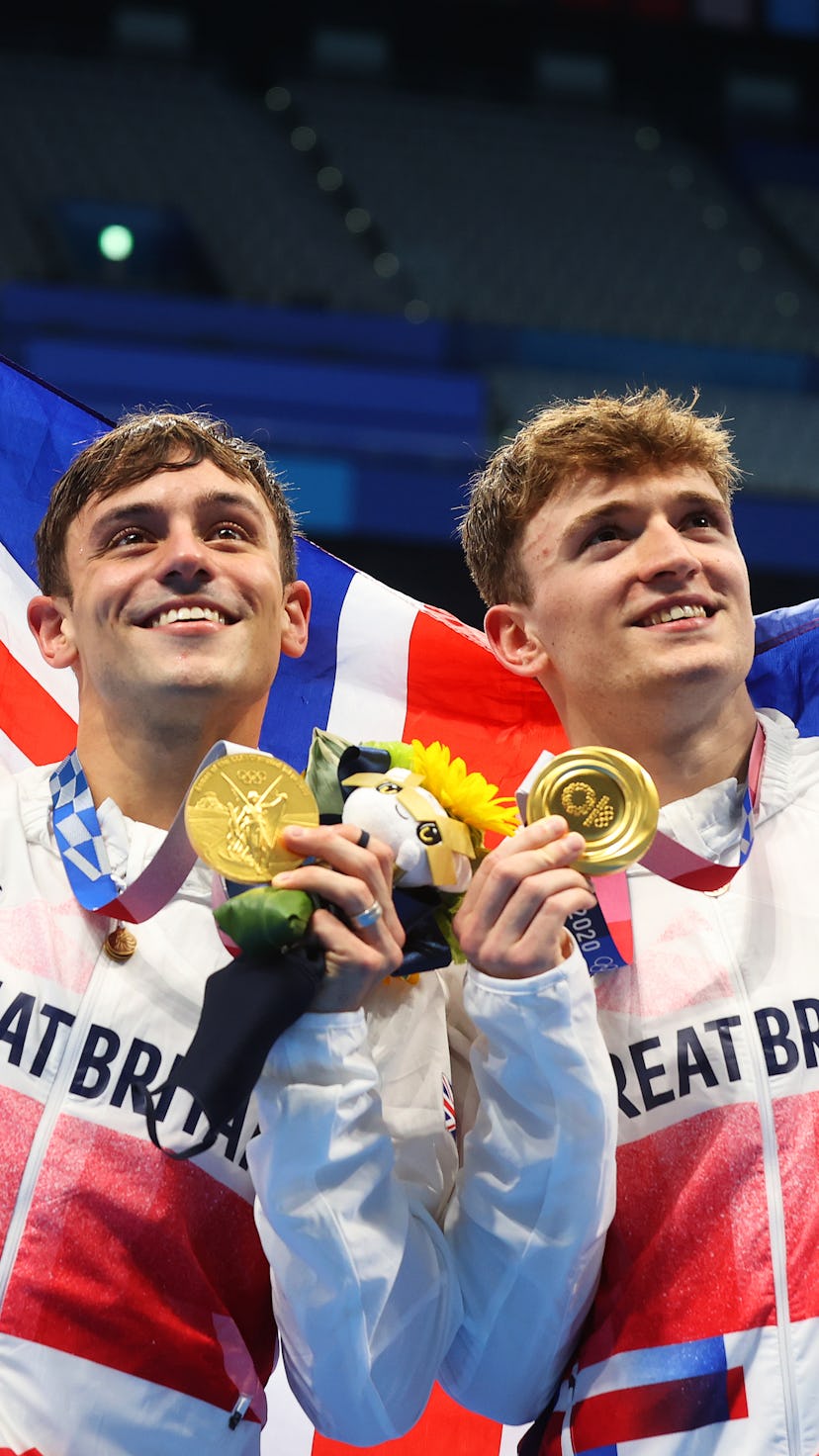 Tom Daley and Matty Lee of Team Great Britain pose for photographers with their gold medals after wi...