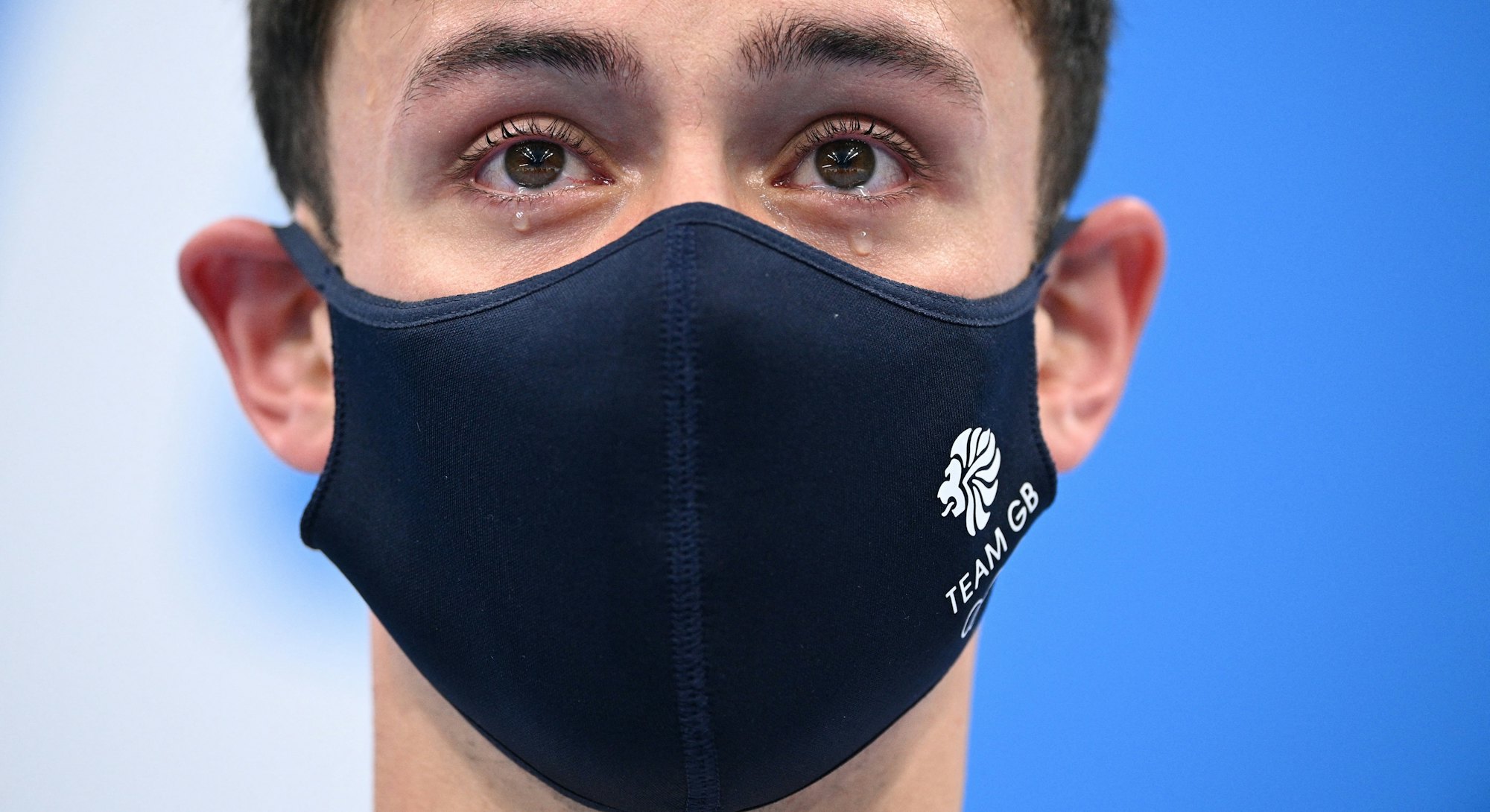 Tears well in the eyes of gold medallists Britain's Thomas Daley and Britain's Matty Lee (unseen) as...