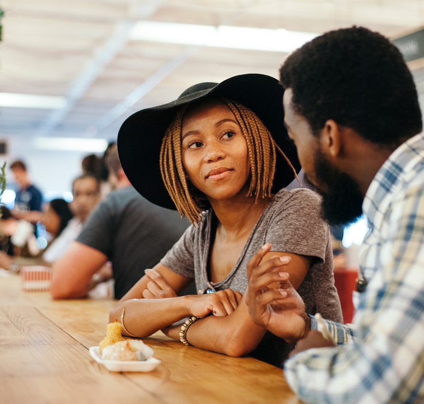 Young trendy ethnic African couple eating Chinese Food in trendy market in Braamfontein Johannesburg...