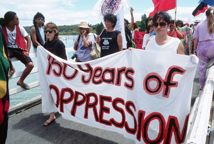 Protesters hold a banner reading "150 years of OPPRESSION" during Queen Elizabeth's visit to New Zea...