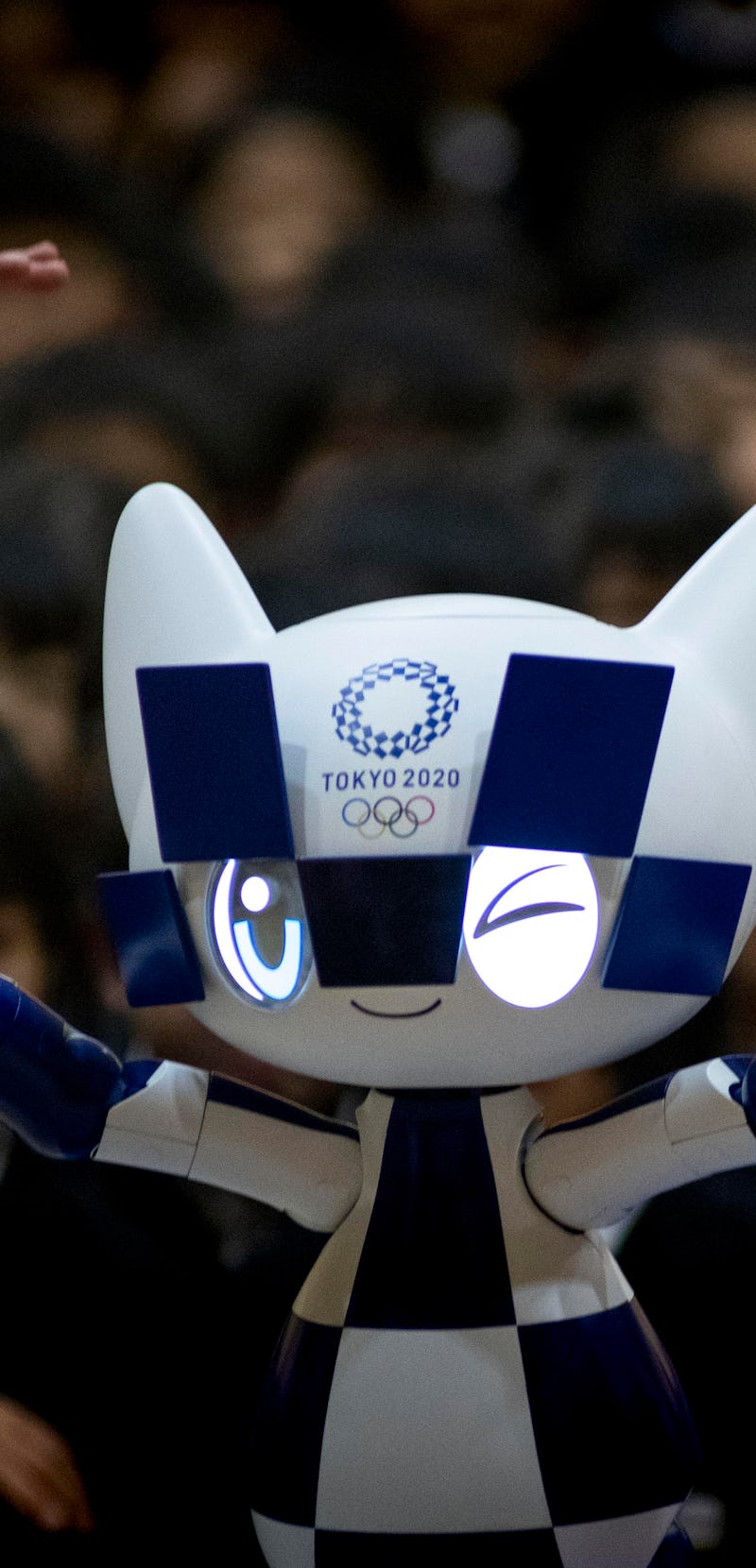 Schoolchildren pose for a picture with Tokyo 2020 Olympic Games' robot-type mascot Miraitowa during ...