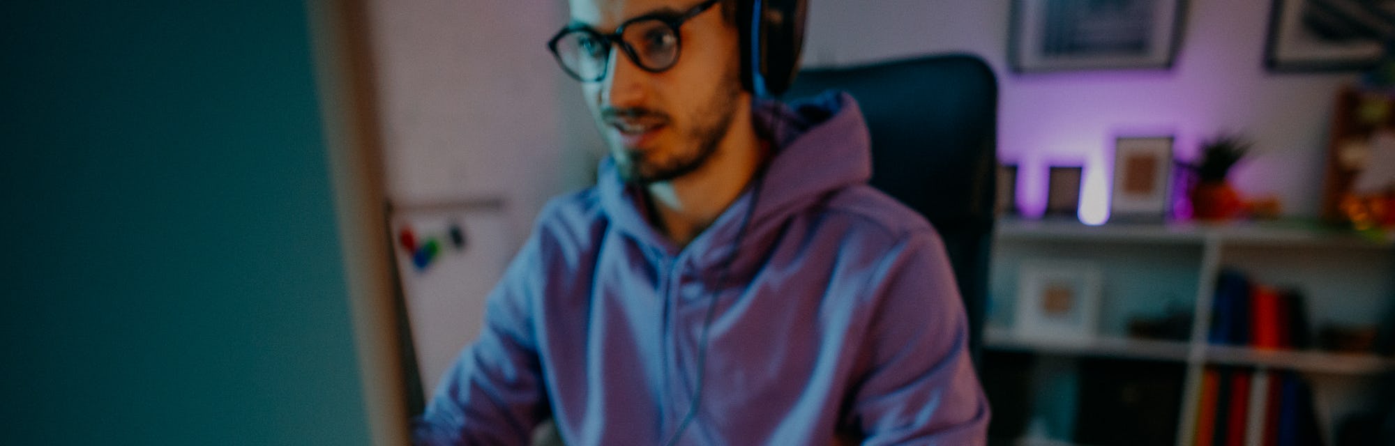 Young man playing online video games at home on PC