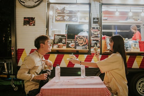 Teenage boy introduce himself with a hamburger for live streaming while dining with girlfriend to ma...